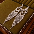 Macro detail of silver tassel earrings with sparkling rhinestones on green velvet - Silver (925 Sterling Silver Earring Post)