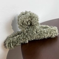 Detail view of olive green plush faux fur shark hair claw clip with curly texture finish - Bean Green