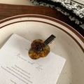 Detailed view of a brown tortoiseshell rose hair clip with golden metal accents - Amber