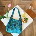 Blue and green floral canvas tote bag with wide shoulder straps on a modern coffee table - Emerald Green Floral