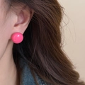 Boucle d'oreille ronde rose vif portée, finition brillante de style dopamine moderne - Rouge