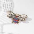 Vintage gold bee brooch with pearls, blue enamel, and red rhinestones for suits - Bronze