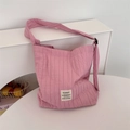Detailtextuur van roze geplooide canvas draagtas met geweven merklabel en brede riem - Roze