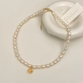 Dettaglio della collana di perle d'acqua dolce con ciondolo smiley dorato e chiusura - Pendaglio Faccina Sorridente