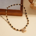 Détail du collier en œil de tigre avec un pendentif nœud scintillant et des accents dorés - Collier-Oeil de Tigre Brun Noeud (Plaqué Or)