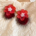 Detailansicht der roten Acryl-Blütenohrringe mit Plüsch-Pompon auf strukturiertem Papier - Silberner Ohrring-Stift - Rot