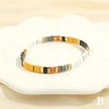 Detail view of colorful Tila enamel tile beads on an elastic bohemian beach bracelet - Multicolor B-Yellow White Black Gold Grey Orange Brown