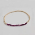 Close-up of beaded bracelet with gold round beads and purple faceted natural stones - Purple Tourmaline