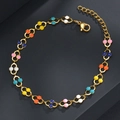 Detalle de pulsera de cadena dorada con cuentas de esmalte de colores y cierre de mosquetón - Forma de U