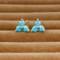 Detailed shot of clover stud earrings with blue faceted stones in gold-plated settings - Gold/Blue Zirconia