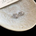 Macro shot of silver metal clip-on earring converters with clear silicone pads on ceramic - Earring Converter-Silver-Triangle