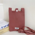 Macro detail of pink knitted phone bag texture with silver button and brand label - Lotus root pink