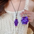 Primer plano de colgante de pez en concha púrpura con ojo azul en blusa blanca - Morado