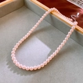 Close-up of pink pearl necklace with silver adjustable chain on a grey velvet tray - 6mm Pink Pearl Style / Pink