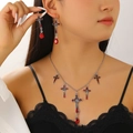 Primo piano di set collana e orecchini gotici con croci rosse su modella femminile - 05 Croce in Argento Antico H-235 (Set da due pezzi)