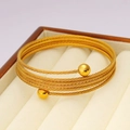 Dettaglio macro di un bracciale rigido dorato multifilo con estremità a sfera - Bracciale In Oro Ck1094-5