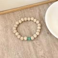 Minimalist white lava stone beaded bracelet with a single green agate accent bead - Lava Stone & Green Cat's Eye