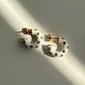 Detail of gold C-shaped earrings with white enamel and sparkling zircon stones - White