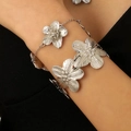 Silver flower textured metal bracelet and bangle set shown on model wrist for women - Silver Flower Bangle + Bracelet Set