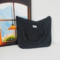 Close-up of black floral canvas tote bag with white polka dots and woven brand label - Black Polka Dot