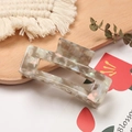 Minimalist marble pattern acetate hair claw clip shown on a rustic wooden tray - Iridescent Gray