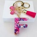 Close-up of resin letter F keychain with pink butterfly pendant and fuchsia tassel - Rose Red Butterfly Tassel Clip / Letter F