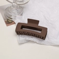 Detailed close-up of a matte brown hollow rectangular hair claw clip on textured background - Cube / Dark Coffee