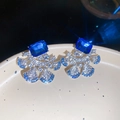 Close-up of elegant fan-shaped earrings with vibrant blue rectangular stones and crystals. - 60# Silver Pin-Silver-Blue