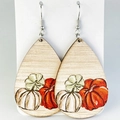 Dettaglio di orecchini pendenti in legno a goccia con motivi di zucche autunnali colorate - Zucca a forma di goccia