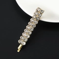 Single gold bobby pin with sparkling round rhinestones on a white ceramic plate - Double Row Large Rhinestones / Gold