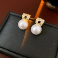 Détail de boucles d'oreilles perles avec accents géométriques dorés et petits cristaux - Doré