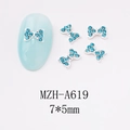 Macro view of blue rhinestone nail art bow MZH-A619 measuring 7x5mm on a light blue nail - Wide Bright Blue Full Rhinestone Bow (A619)