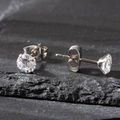 Macro detail of 5mm round clear zircon earrings with silver four-claw stainless steel setting - 5mm / Silver