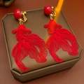 Detailaufnahme roter Koi-Ohrclips auf einer Schmuckschatulle mit warmem Lichteinfall - Hohle Goldfisch Ohrclips / Gold/Rot