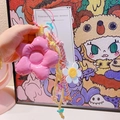 Gros plan du porte-clés fleur en cuir rose avec corde tressée colorée et charm sourire - 42.A08 Grande Fleur Rose