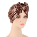 Detail of bronze sequined turban hat featuring a decorative knot bow on a mannequin - Khaki
