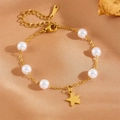 Golden chain bracelet with white pearls and a star pendant on silk background - Star Bracelet