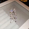 Gros plan de boucles d'oreilles feuilles en argent avec zircons sur du velours - Argent (Tige en argent)