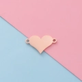 Macro view of a polished rose gold heart charm with dual holes on a pastel background - Rose Gold