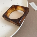 Macro shot of geometric acrylic resin bangle with warm amber tortoiseshell pattern - Amber Brown