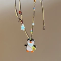 Detail view of penguin avocado pendant necklace with colorful beads and starfish - Brown Penguin Avocado (18# Necklace)
