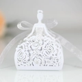 Macro detail of laser-cut white favor box with intricate rose patterns and ribbon - White