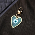Detail of a heart-shaped evil eye keychain with blue enamel and gold-tone alloy hardware - Light Blue Heart