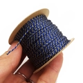 Close-up of 1mm blue and gold twisted cotton cord wrapped on a kraft paper spool - Blue