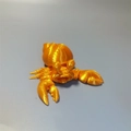 Detailed macro view of a 3D printed hermit crab toy in vibrant golden plastic finish - Hermit Crab / Silk Orange