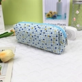 Détail de la trousse en coton matelassé avec carreaux bleus et jaunes sur un bureau - Pois bleus