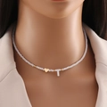 White beaded necklace with gold heart and shell letter T pendant on a female model - Letter T
