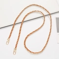 Detail of gold metal chain woven with brown leather strap and dual lobster clasps - Tan