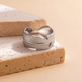 Detailed macro shot of silver feather ring with intricate textures on stone pedestal - Leaf Steel Color 86-1