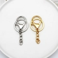 Detailed view of silver and gold metal lobster clasps and key rings on a white plate - 4-Section Chain Lobster Clasp / Silver